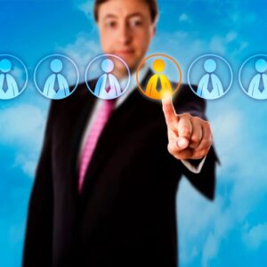 A man in a suit and tie pointing to an image of people.